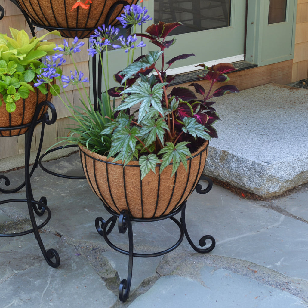 Decorative plant stand with a pot of plants on a stone patio. Henderson Garden Supply