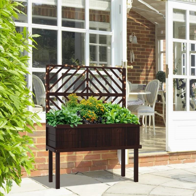 Wooden planter box with plants on a patio area in front of a house. Henderson Garden Supply