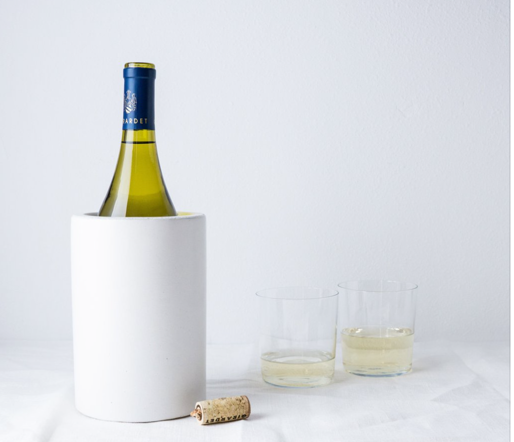 White wine bottle in a cooler with two glasses of white wine on a light gray background,  Henderson Garden Supply