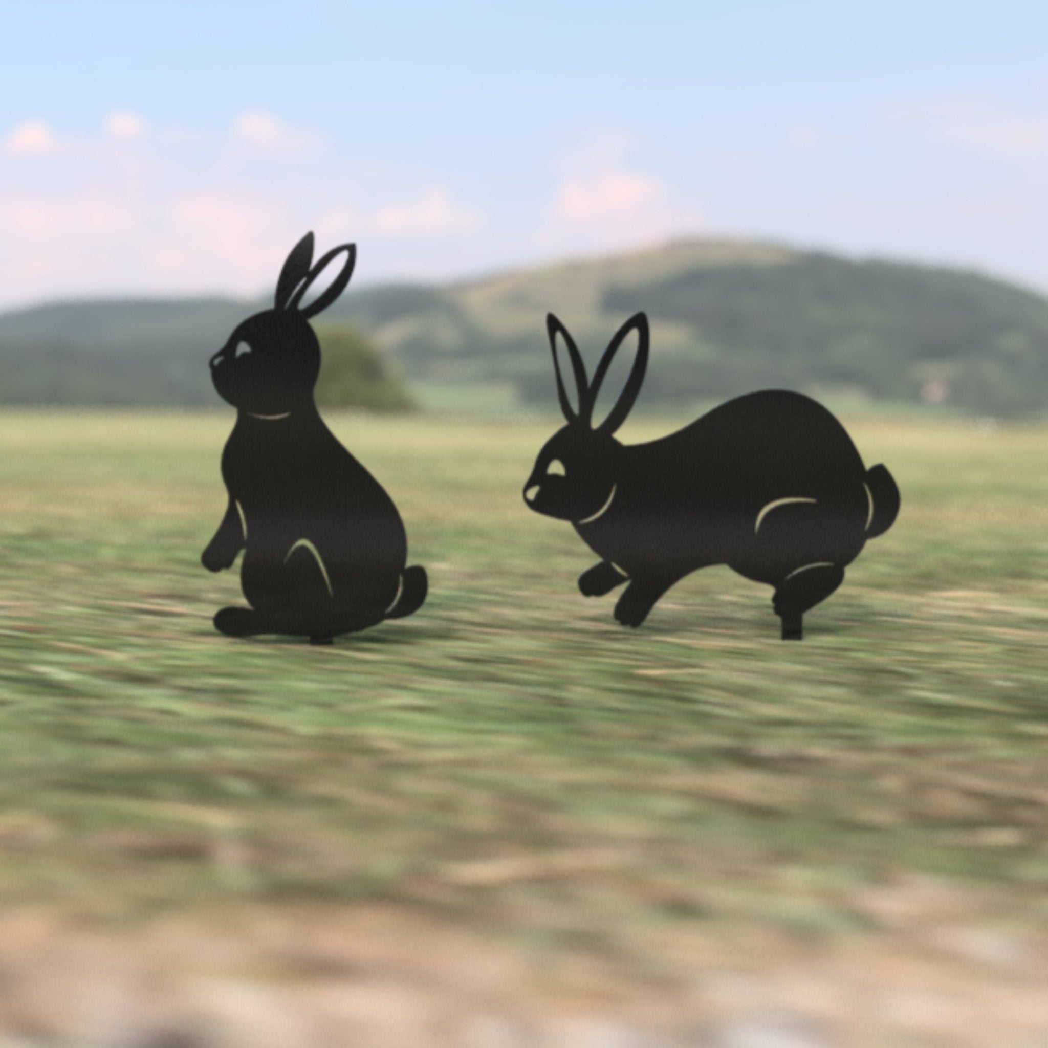 Black rabbit silhouettes on a grassy field with hills in the background.  Henderson Garden Supply
