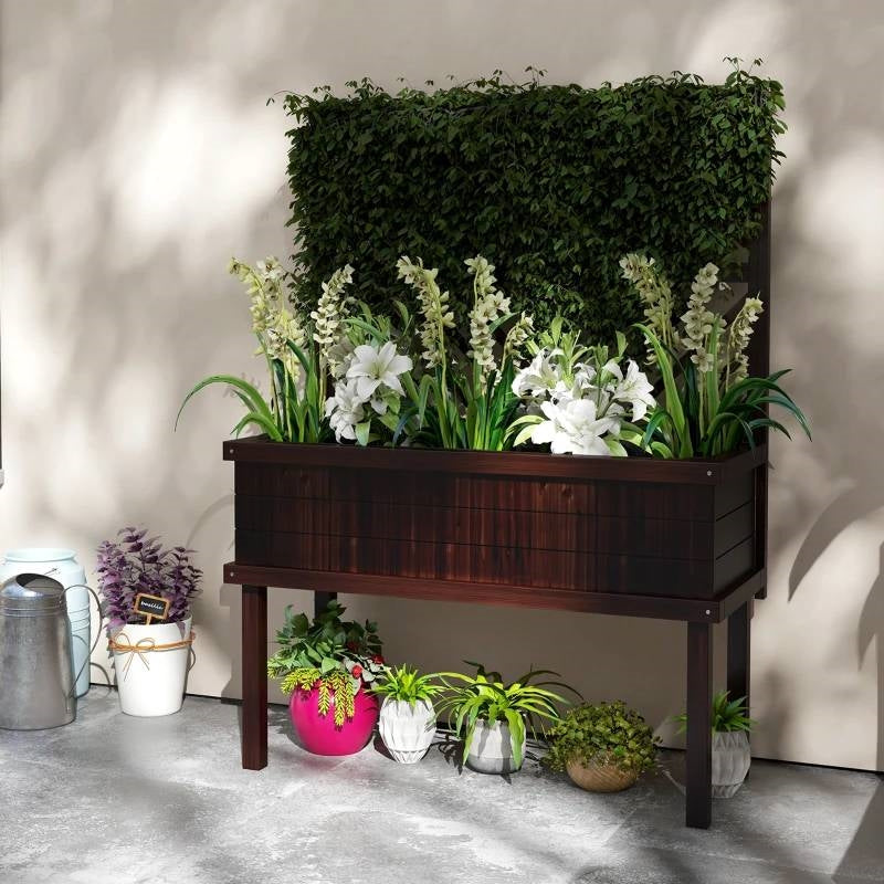 Wooden planter box with greenery and white flowers on a concrete floor.  Henderson Garden Supply
