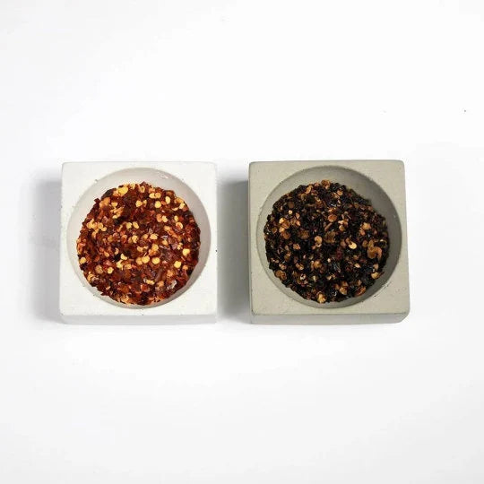 Two square concrete containers with ground pepper on a white background.  Henderson Garden Supply